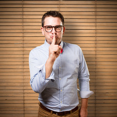 Man wearing a red bow tie. Doing silence gesture.