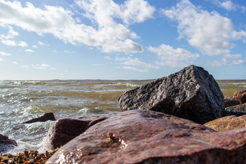 The waves breaking on a stony beach, forming a spray