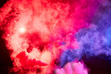 Fototapeta premium Color smoke on black background. Colorful red and blue background for photo shoot. Colored smoke illuminated by flash