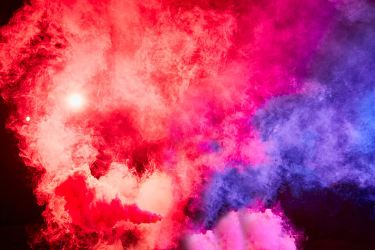 Color smoke on black background. Colorful red and blue background for photo shoot. Colored smoke illuminated by flash