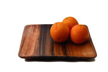 Oranges on a wooden plate