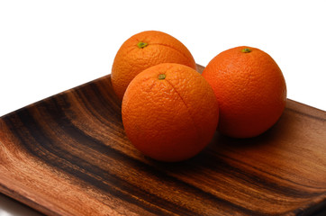 Oranges on a wooden plate