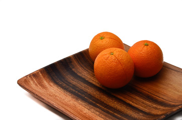 Oranges on a wooden plate