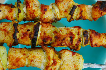 Juicy grilled chicken meat and onion on a blue background. Abstract food background. Fried meat.
