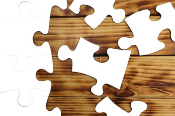  White puzzles lie on a wooden background