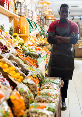 Obraz premium Seller of fruits and vegetables store standing with crossed arms