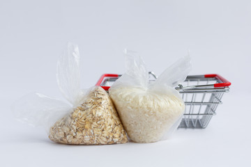 various groats near the grocery basket on a white background