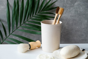 Eco friendly bathroom accessories on table. Natural wooden toothbrushes, shaving brush, organic soap. Minimalist nordic scandinavian style. Zero waste, sustainable lifestyle concept © photoguns