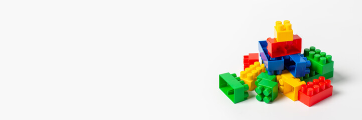 Multicolored designer parts on an isolated white background. Educational toys, logic. Banner