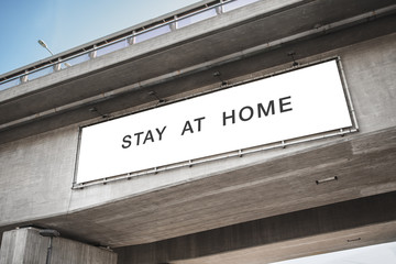 quarantine, caution and epidemic concept - big white billboard with stay at home words on concrete bridge