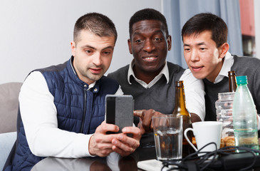 Fototapeta premium Cheerful male friends with phone