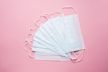 Disposable medical face masks. The concept of prevention of the virus. Pink background. Copy space.