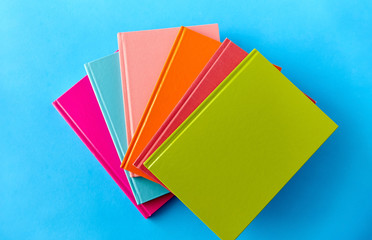 education and object concept - notebooks or books on blue background