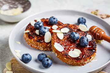Tofu pancakes with blueberries and honey on gray plate. Healthy vegan food concept.