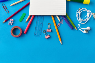 education, office and object concept - notebook and stationery or school supplies on blue background