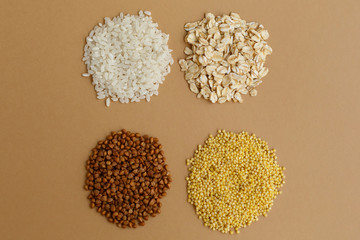 handfuls of various cereals on a brown background