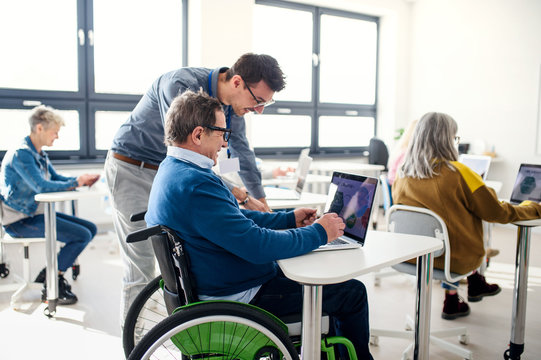 Senior man in wheelchair attending computer and technology education class.
