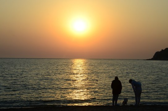 sunset and silhouette of a couple on the beach
