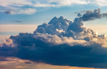 Obraz premium Dark blue Cumulus clouds against a blue sky, illuminated by the sun