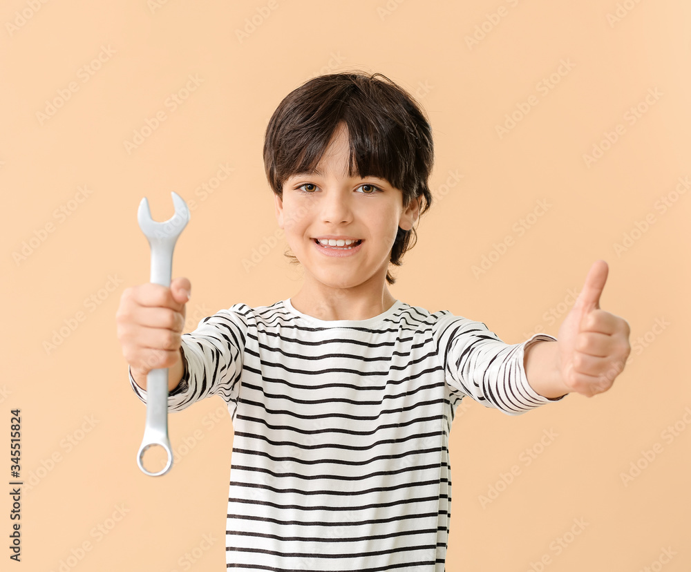 Poster portrait of little plumber showing thumb-up gesture on color background