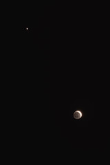 Young Moon and Venus on a dark night sky.