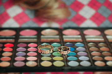 Wedding rings lie on a beautiful bouquet as bridal accessories