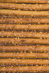 Sesame coated crispy bread bread sticks.
Closeup .Top view , background .