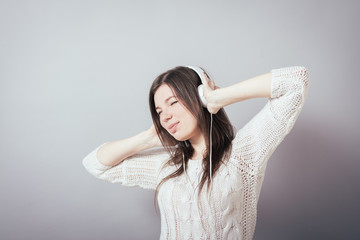 Fototapeta premium Young woman with headphones listening music .Music teenager girl dancing against isolated white background