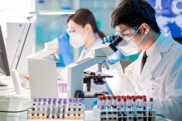 man scientist use microscope