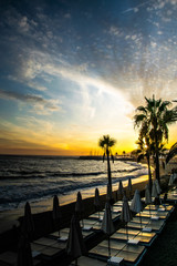 Fototapeta na wymiar a colourful sunset scene of empty sun loungers on a beach in Marbella, Spain 