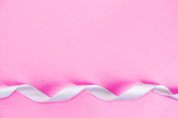 satin decorative white ribbon on a pink background