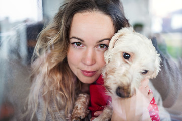 Young woman relaxing indoors at home with pet dog.