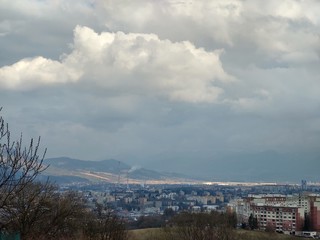 Sunrise and sunset, beautiful clouds over the meadow, hills and buildings in the town. Slovakia