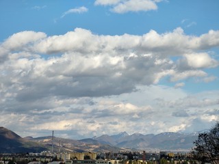 Sunrise and sunset, beautiful clouds over the meadow, hills and buildings in the town. Slovakia