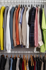 Front view of clothes hung on hangers in the dressing room on the white bar