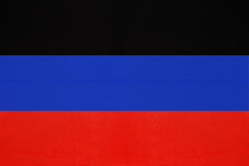 Donetsk People's Republic national fabric flag from textile. Symbol of unrecognized state of Ukraine.