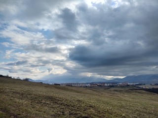 Sunrise and sunset, beautiful clouds over the meadow, hills and buildings in the town. Slovakia