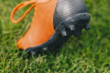 Red soccer cleats on grass sports field