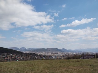 Obraz premium Sunrise and sunset, beautiful clouds over the meadow, hills and buildings in the town. Slovakia