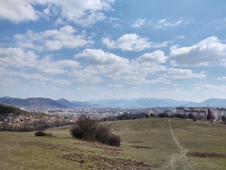 Sunrise and sunset, beautiful clouds over the meadow, hills and buildings in the town. Slovakia