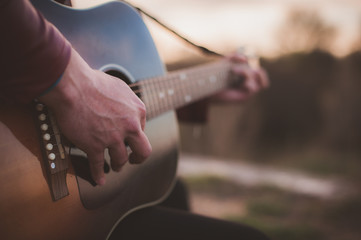 man playing guitar in the field