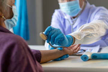 Asian doctor use stethoscope listening lung of patient, elderly health check up , they wear...