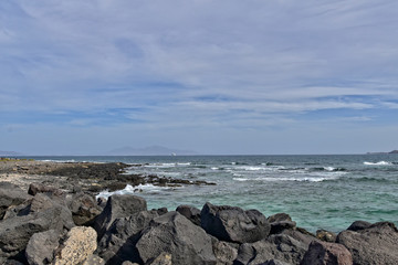 sea landscape with the ocean and a view of the Spanish island of De Lobos with a ship in the background