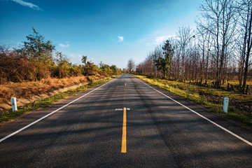 open road. Asphalt road through the green field and clouds on blue sky in summer day. 