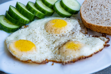 Close up of fried eggs vegetables and bread
