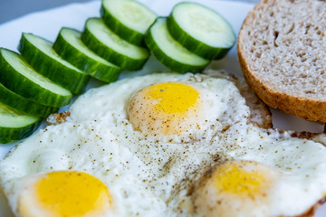 Close up of fried eggs vegetables and bread