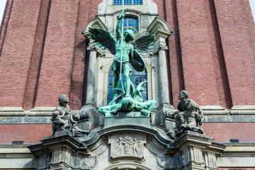 Obraz premium Sculpture of Angel killing a devil in front of Church of St. Michael, Hamburg, Germany. A landmark of the city and it is considered to be one of the finest Hanseatic Protestant baroque churches