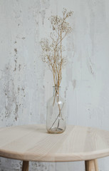 Dried Flowers in the Glass Jar for decoration on wooden table with Empty Wall