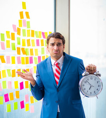 Young handsome employee with many conflicting priorities