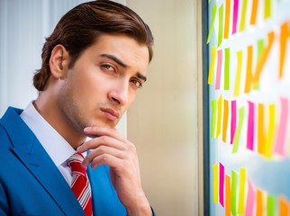 Young handsome employee with many conflicting priorities